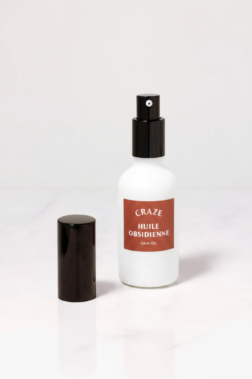 CRAZE Huile Obsidienne Hair Oil bottle uncapped with spray pump and black cap beside it